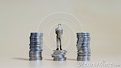 Business concept with a miniature person with a pile of coins. Stock Photo